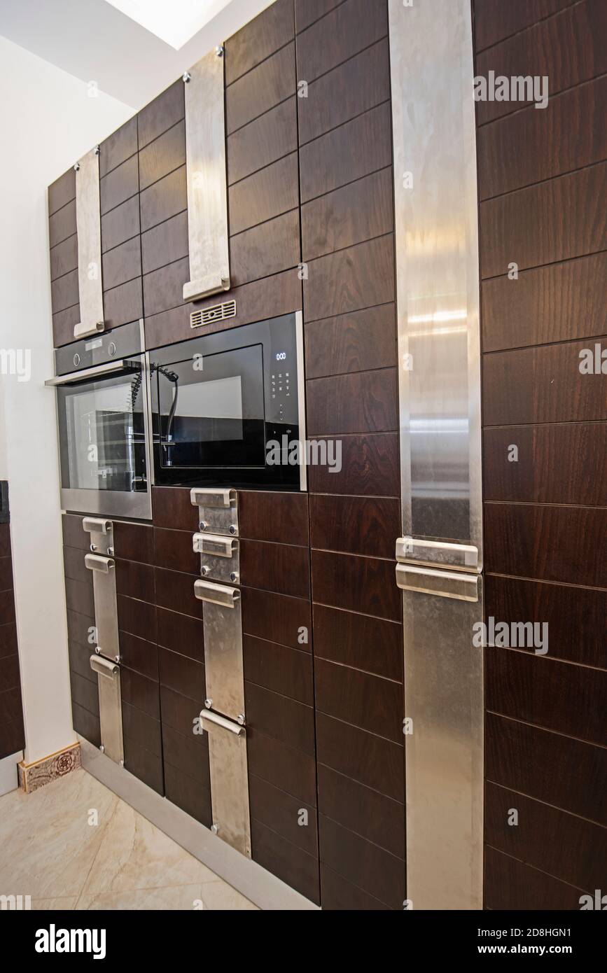 Interior design decor showing modern kitchen with cupboards and built in cooker in luxury apartment showroom Stock Photo