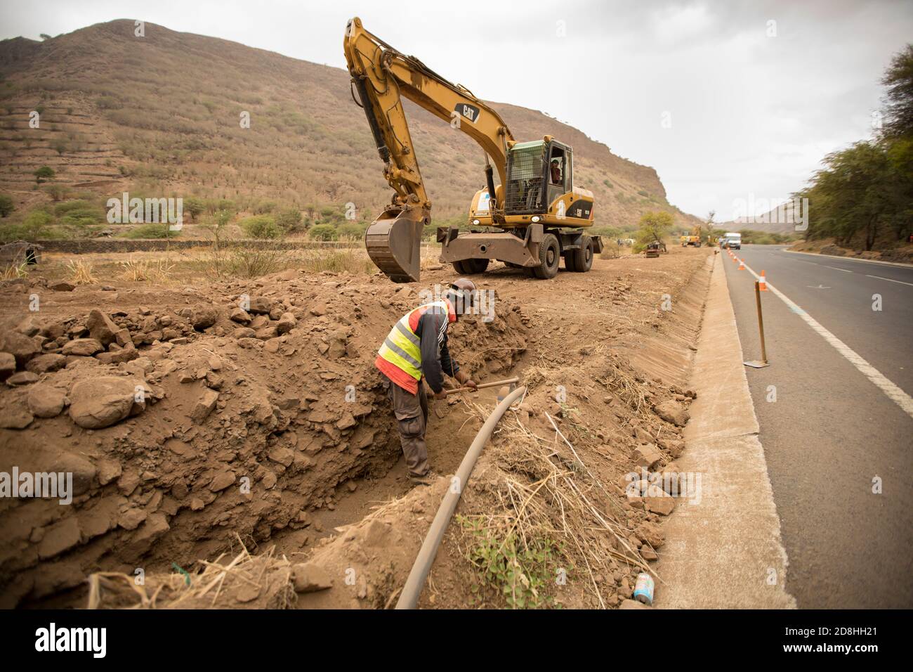A construction crew works to install a new water line underground on