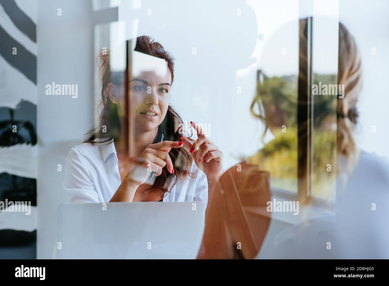 Female coach is consulting young woman Stock Photo - Alamy