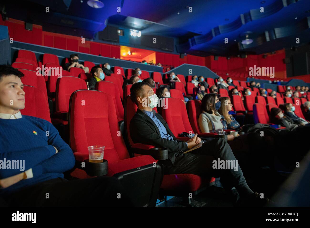 The Genesis cinema in East London during the Covid pandemic. The cinema is sparsely populated and people are spread out, many wearing facemasks Stock Photo