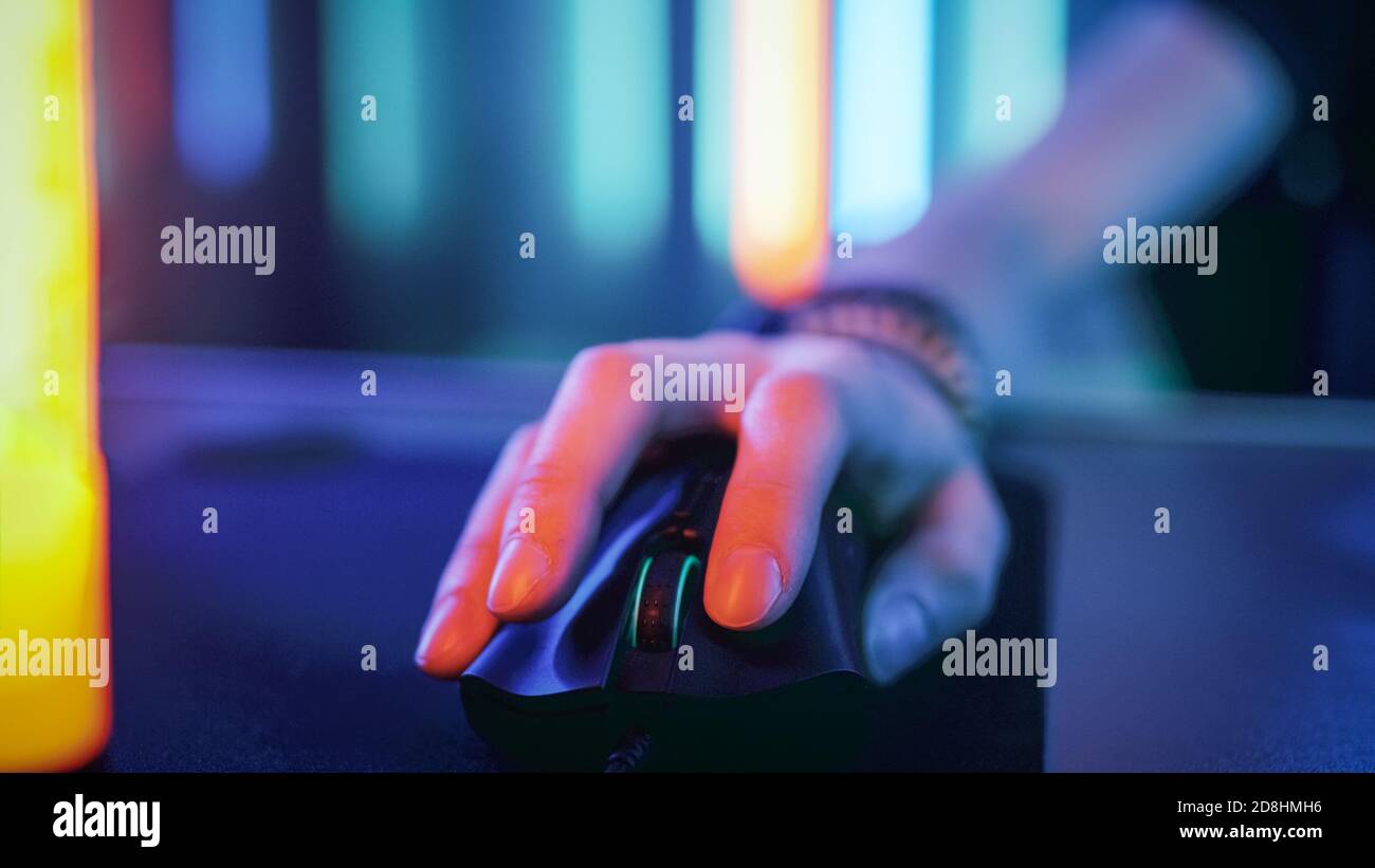 Close-up on the Hand that Uses Computer Mouse. Cool Neon Retro Lights. Browsing in Internet or Playing Online Games. Stock Photo