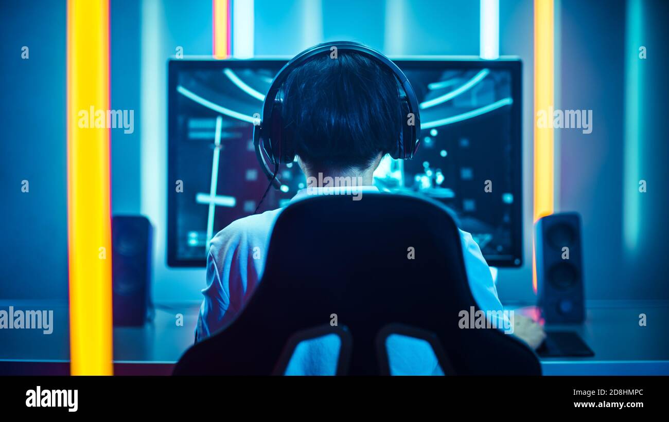 Back shot of pro gamer playing online shooter game on computer using  wireless controller. Competitive player man winning videogame tournament  use professional equipment at home gamming studio Stock Photo - Alamy