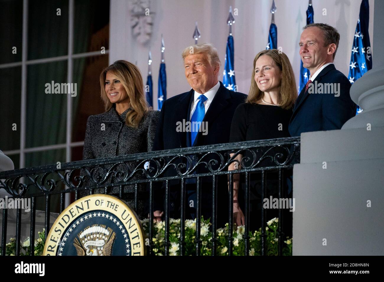 U.S President Donald Trump, First Lady Melania Trump, Supreme Court Associate Justice Amy Coney Barrett, and her husband Jesse Barrett greet invited guests from the Blue Room Balcony of the White House October 26, 2020 in Washington, DC. Stock Photo