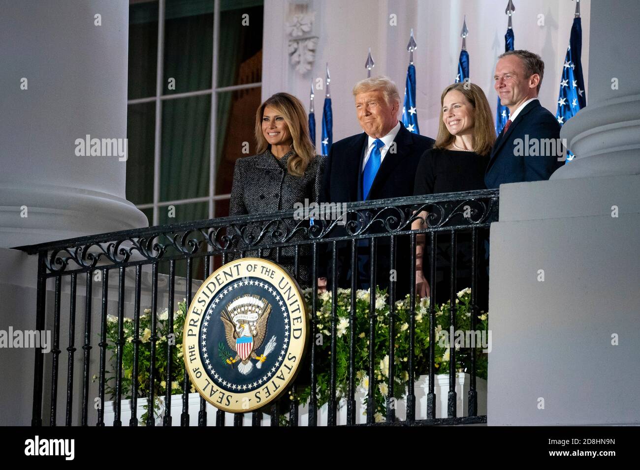 U.S President Donald Trump, First Lady Melania Trump, Supreme Court Associate Justice Amy Coney Barrett, and her husband Jesse Barrett greet invited guests from the Blue Room Balcony of the White House October 26, 2020 in Washington, DC. Stock Photo