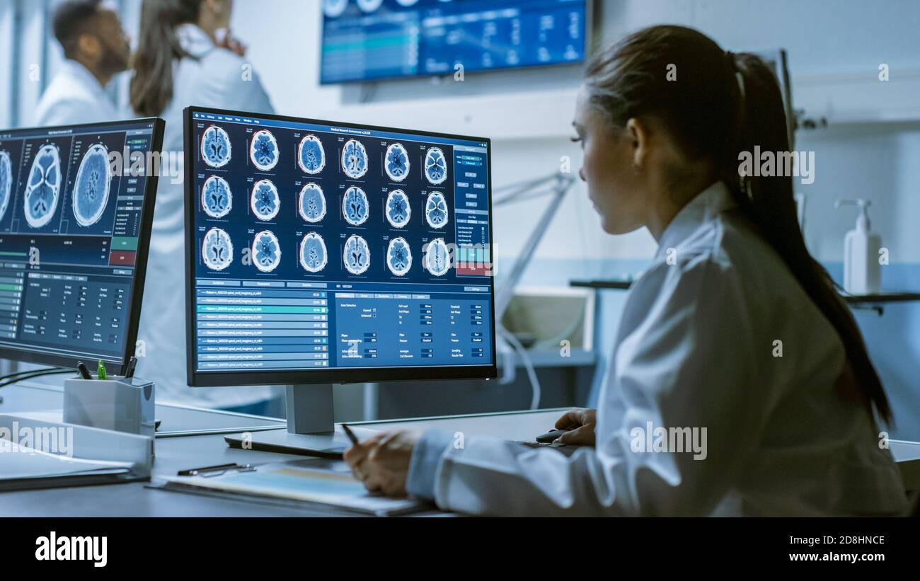Female Medical Research Scientist Working with Brain Scans on Her