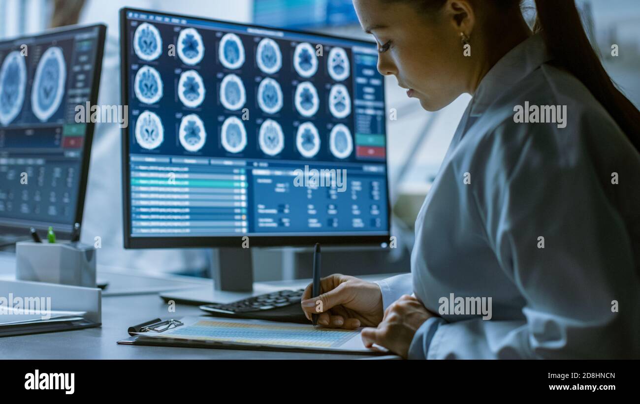 Female Medical Research Scientist Working with Brain Scans on Her