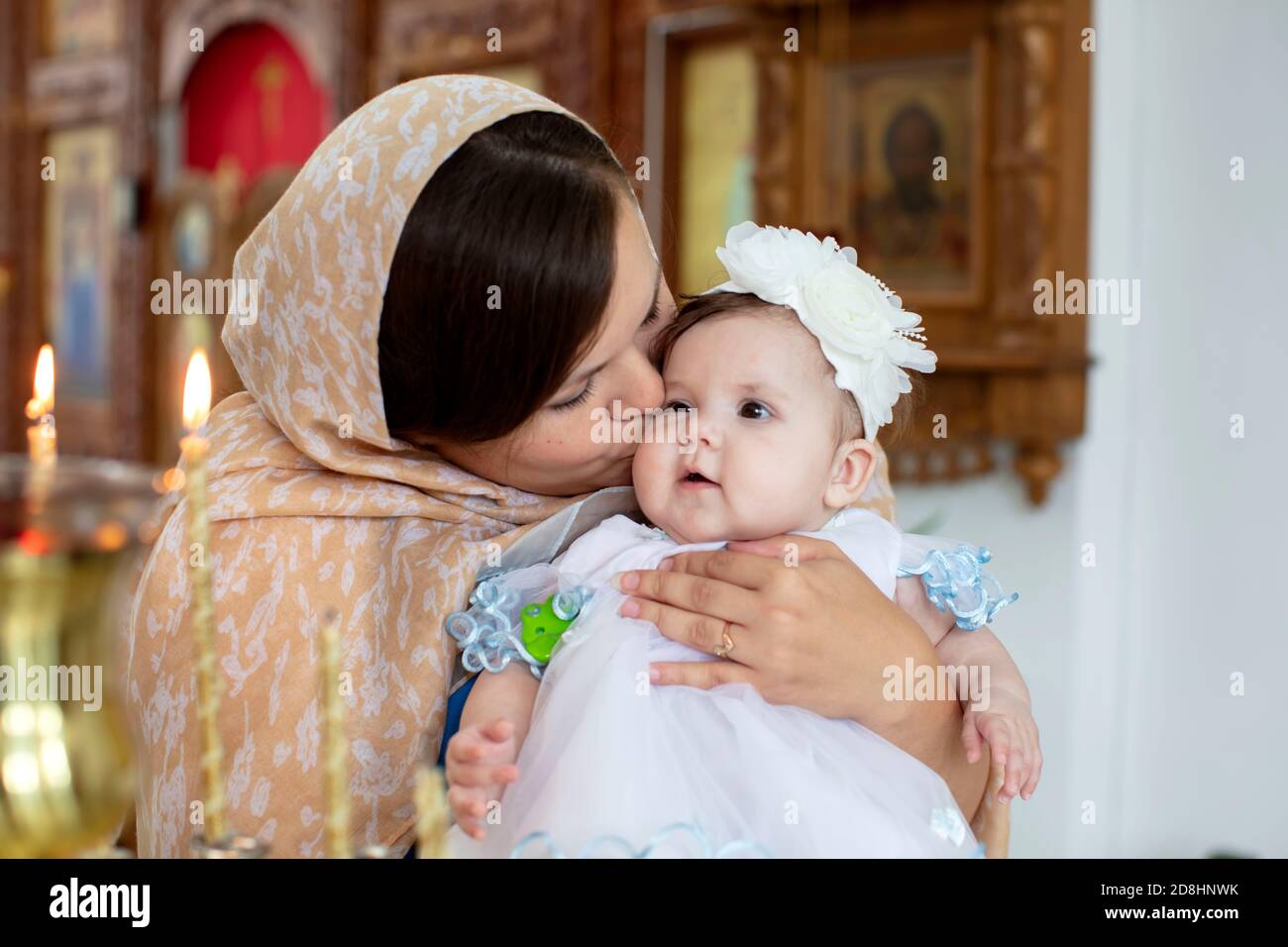 Belarus, Gamel, 15.07.2020. Church of Volotovo. Baptism of the Child.Mom kisses the child in the church. Stock Photo