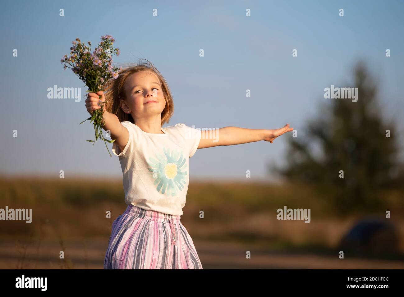 Beautiful little girl in the meadow with a bouquet of flowers. A child ...