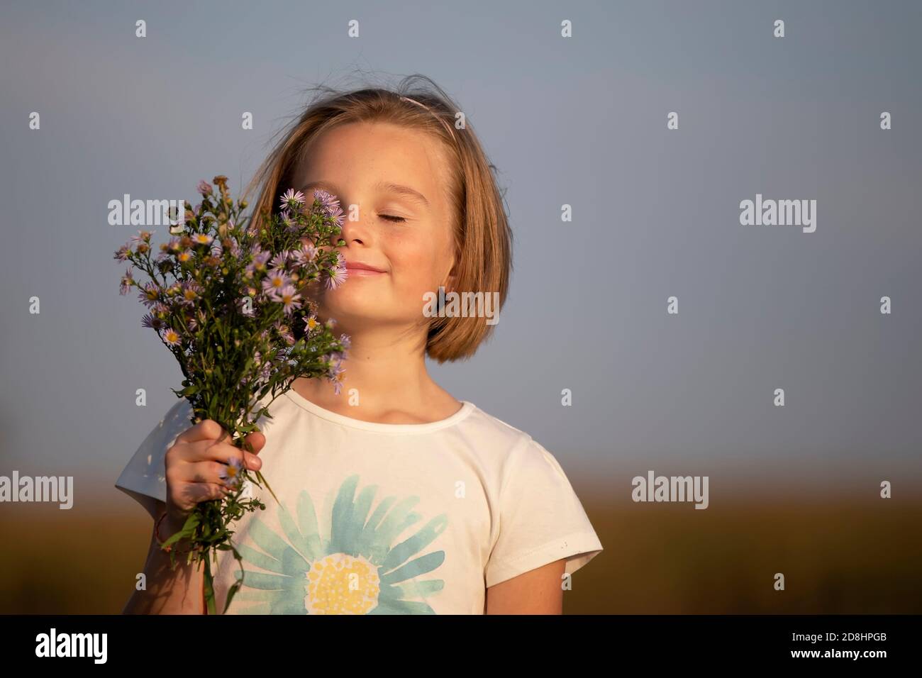Beautiful little girl with a bouquet of meadow flowers. A child in a ...