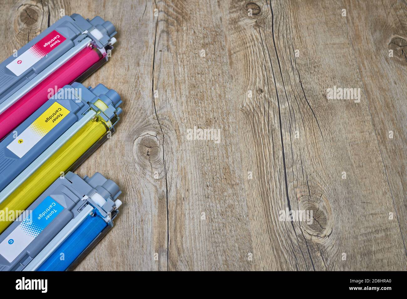 cyan, magenta and yellow toner cartridges for color laser printer on wood Stock Photo