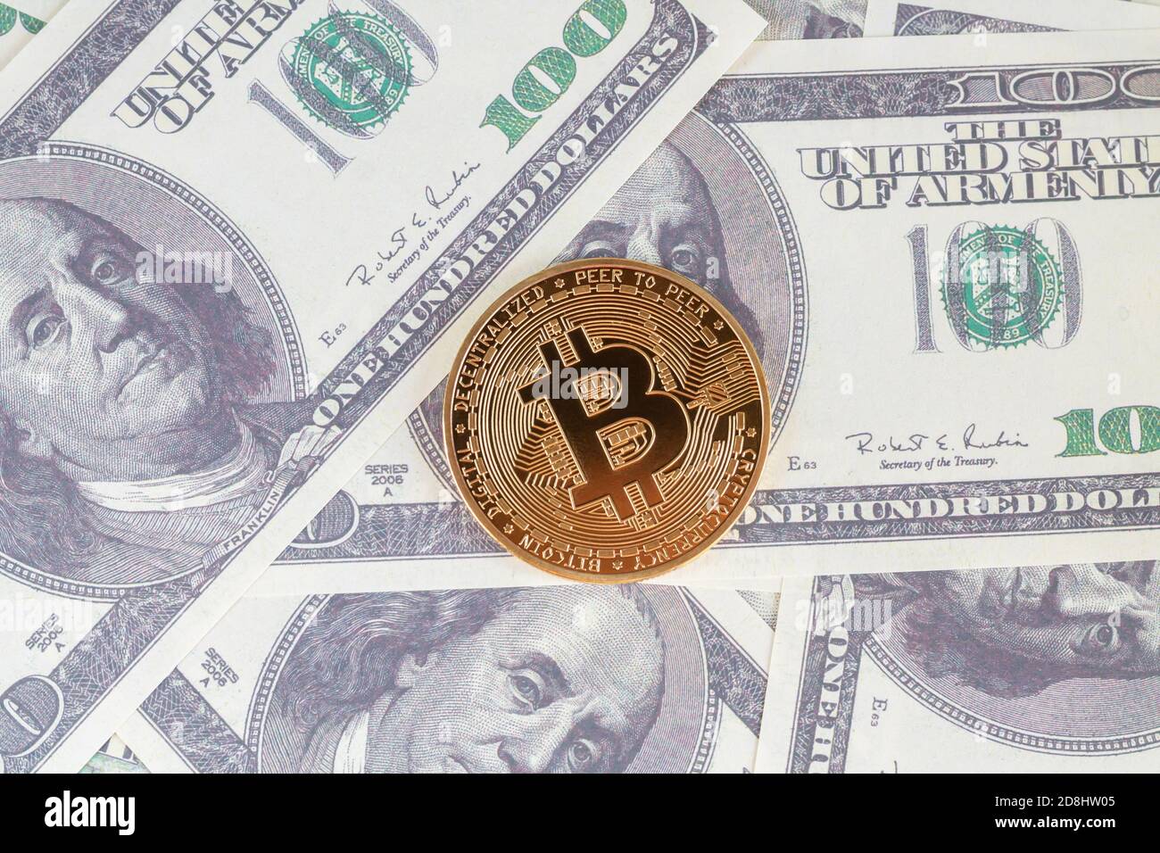 Gold bitcoin on hundred dollars bills top view Stock Photo