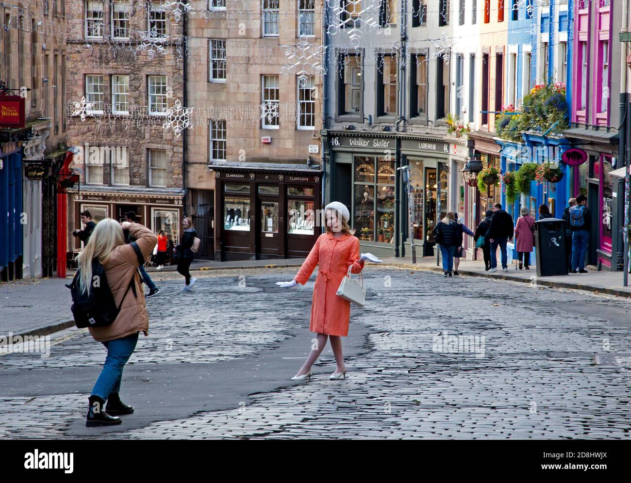 Victoria Street, Edinburgh, Scotland, UK. 30 October 2020. Dull afternoon helped this photographer with subdued light for her fashion shoot in a traffic free Victoria Street, where the road has been closed to motorised traffic in connection with the 'Places For People' initiative. Stock Photo