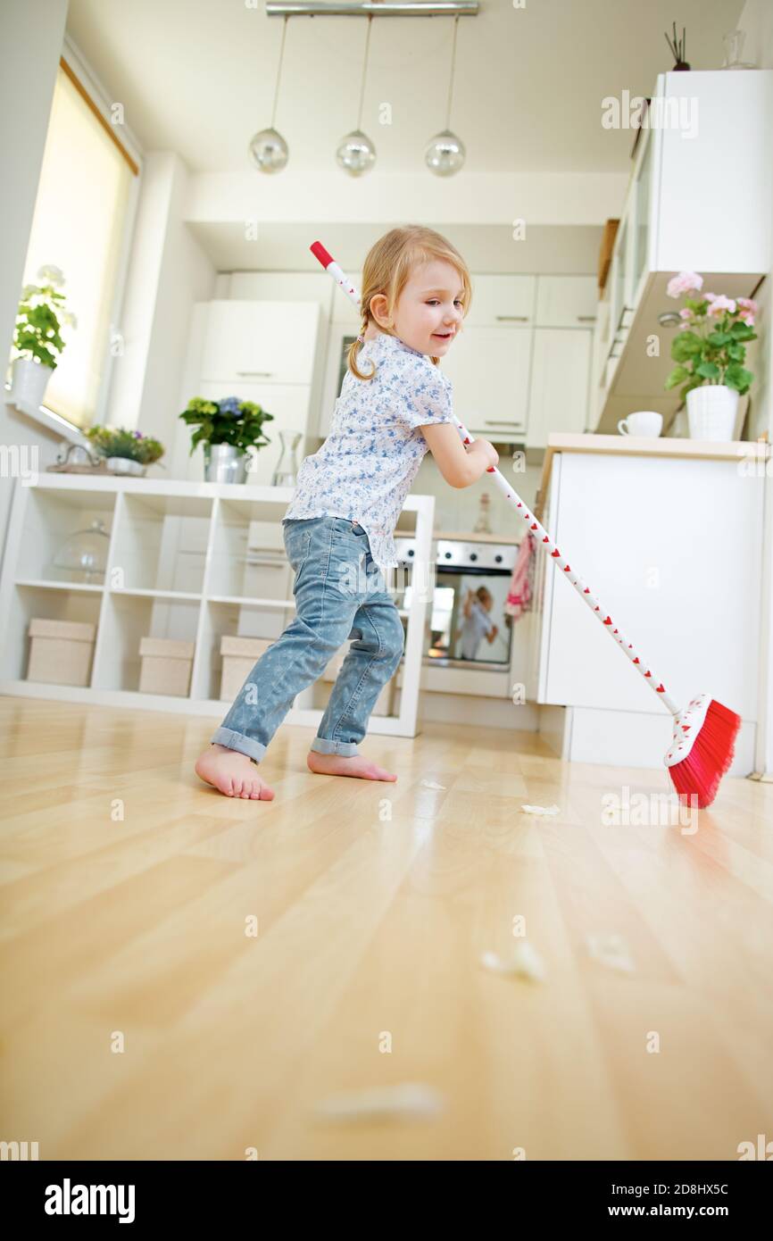 Child sweeping and sweeping with broom at home Stock Photo Alamy
