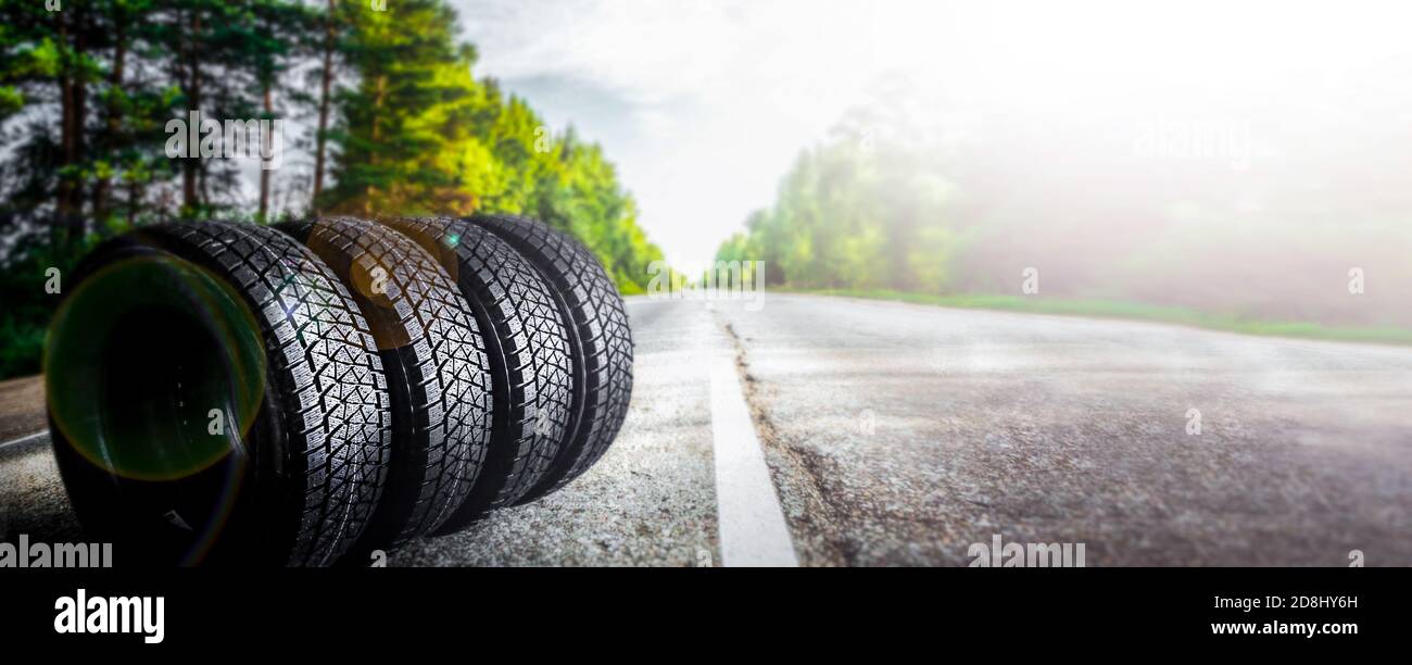 Change a car seasonal tire summer forest road with trees background. Change for winter tire. Banner Selling off. Or Background automechanic  Stock Photo