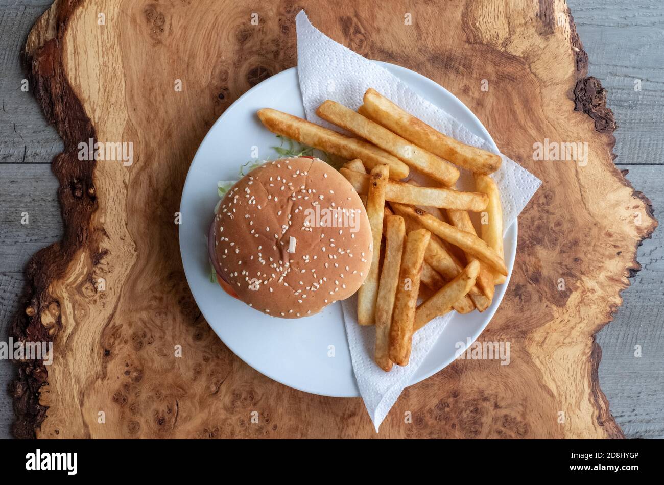Vegan veggie soya burger in bun with salad and relish, and chips on the side. Stock Photo