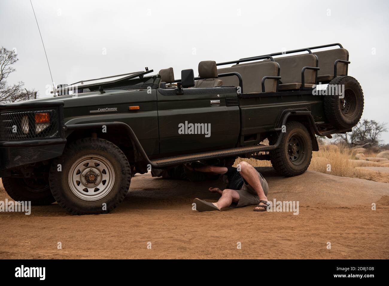 A man checking underneath a vehicle for the source of a rattle Stock Photo