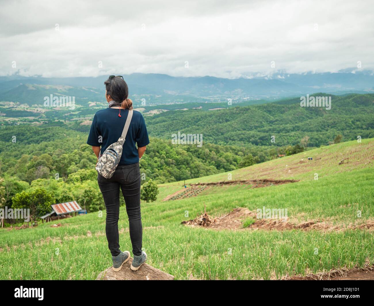 Portrait shot of asian woman from behind with beautiful moutain range and valley. Nature and outdoor concept. Stock Photo