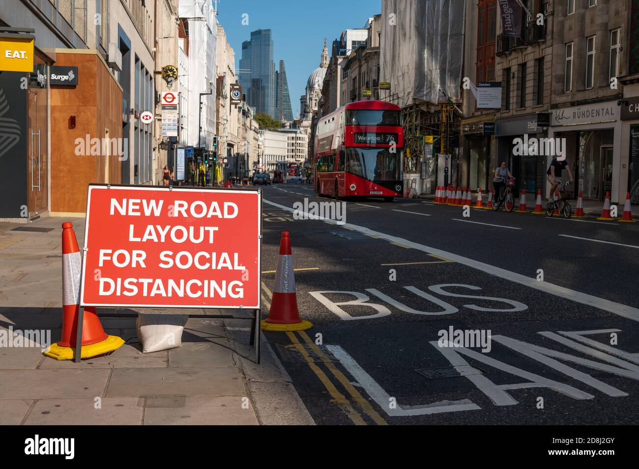 LONDON - SEPTEMBER 13, 2020: Social Distancing new road layout sign with London Double Decker Bus and St Paul's Cathedral in the background during Cov Stock Photo