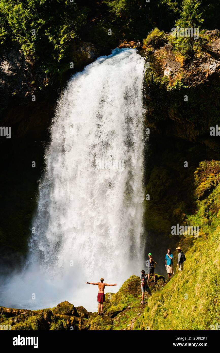 An exuberant water fall watcher stands near Sahalie Falls on the McKenzie River in Oregon. Stock Photo