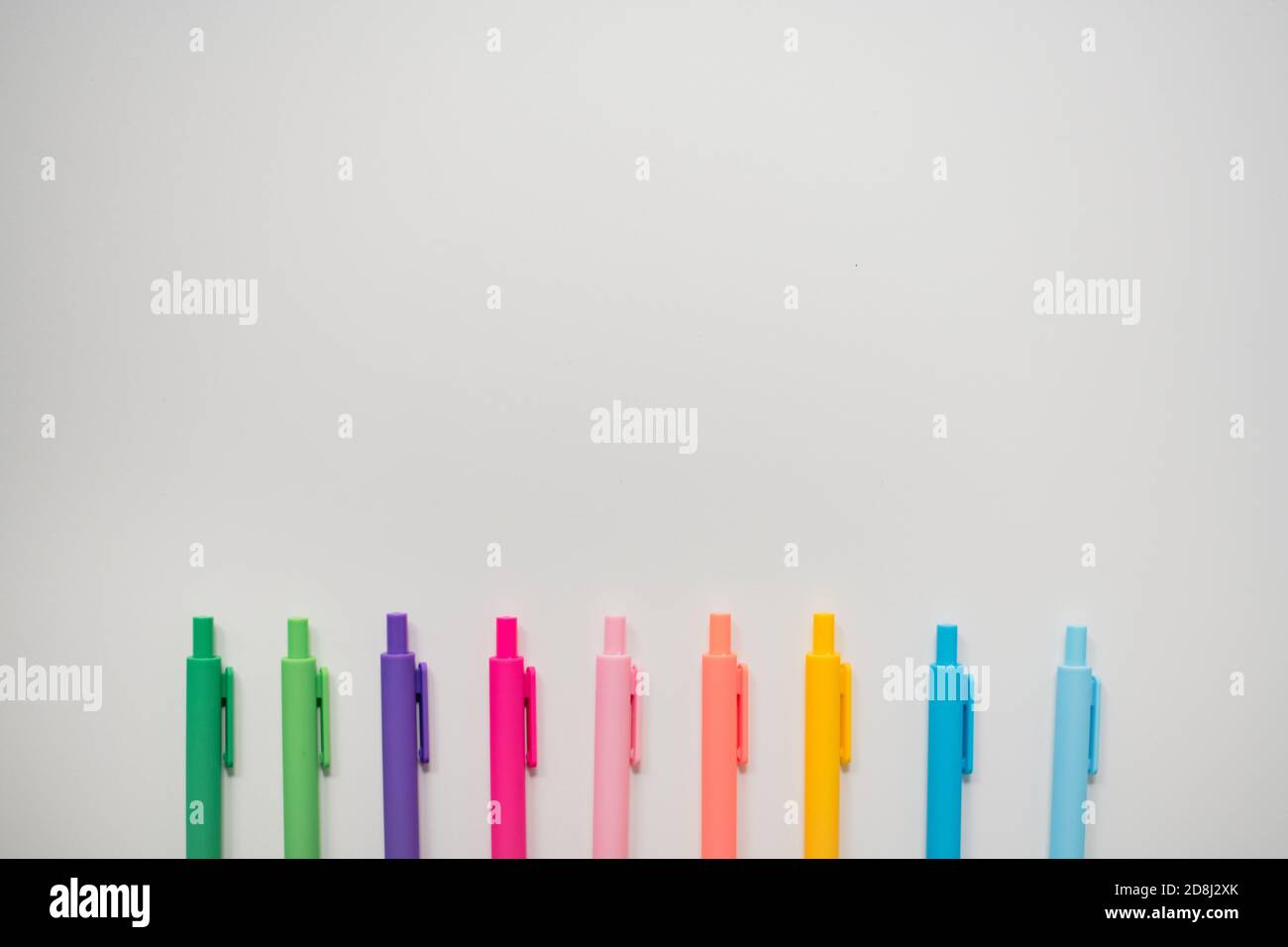 brightly colored markers lined on white background Stock Photo