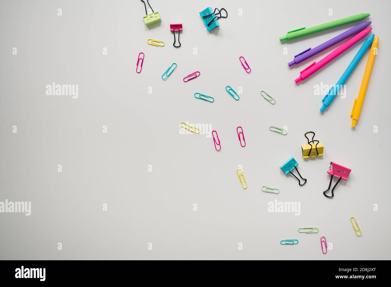 rainbow school supplies on plain white background Stock Photo
