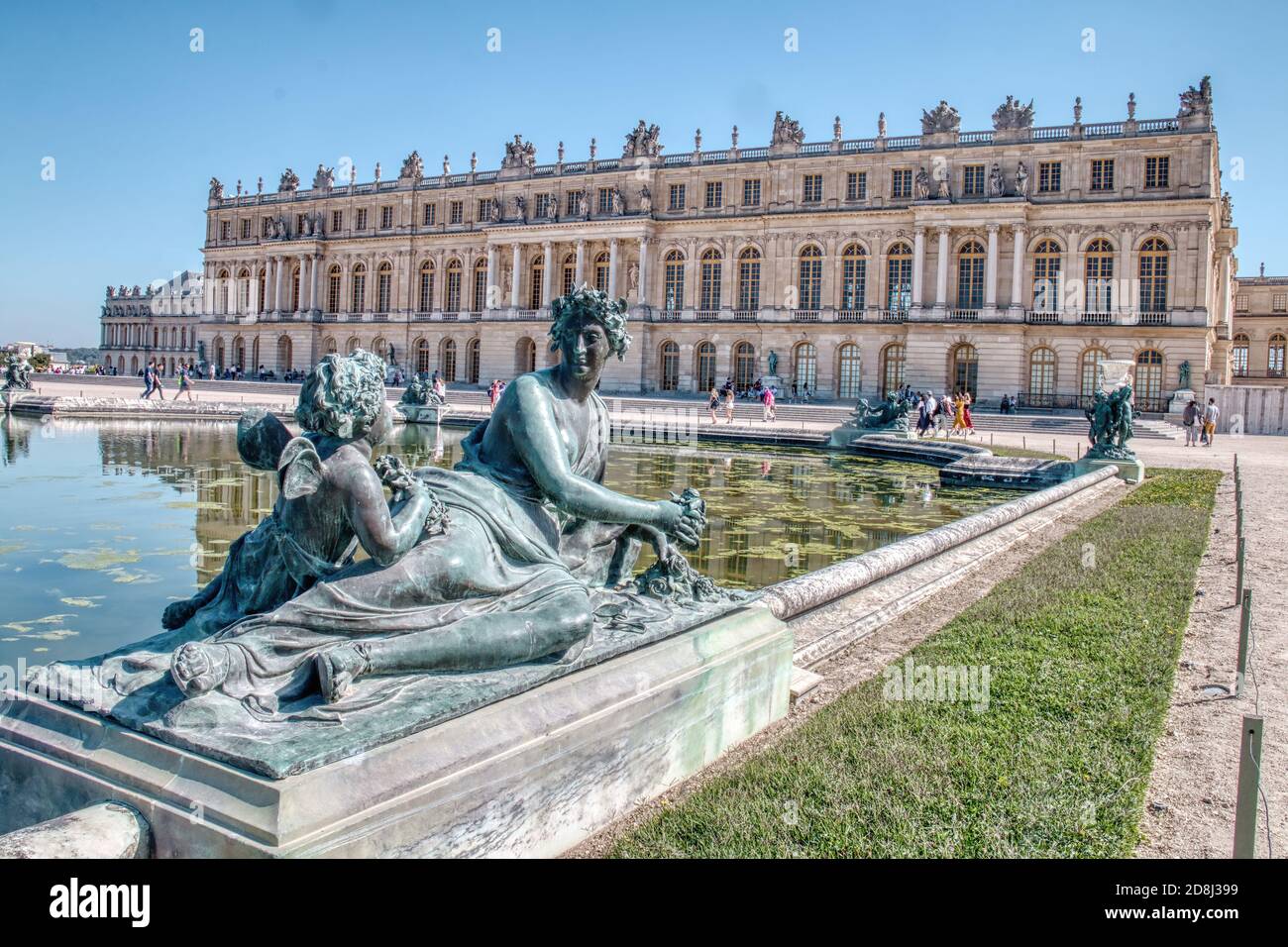 Statues by a pond decorating the gardens of the Palace of Versailles