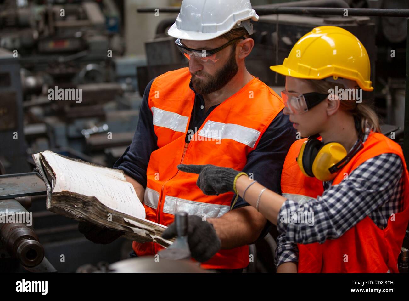 Engineers operating a cnc machine in factory Stock Photo