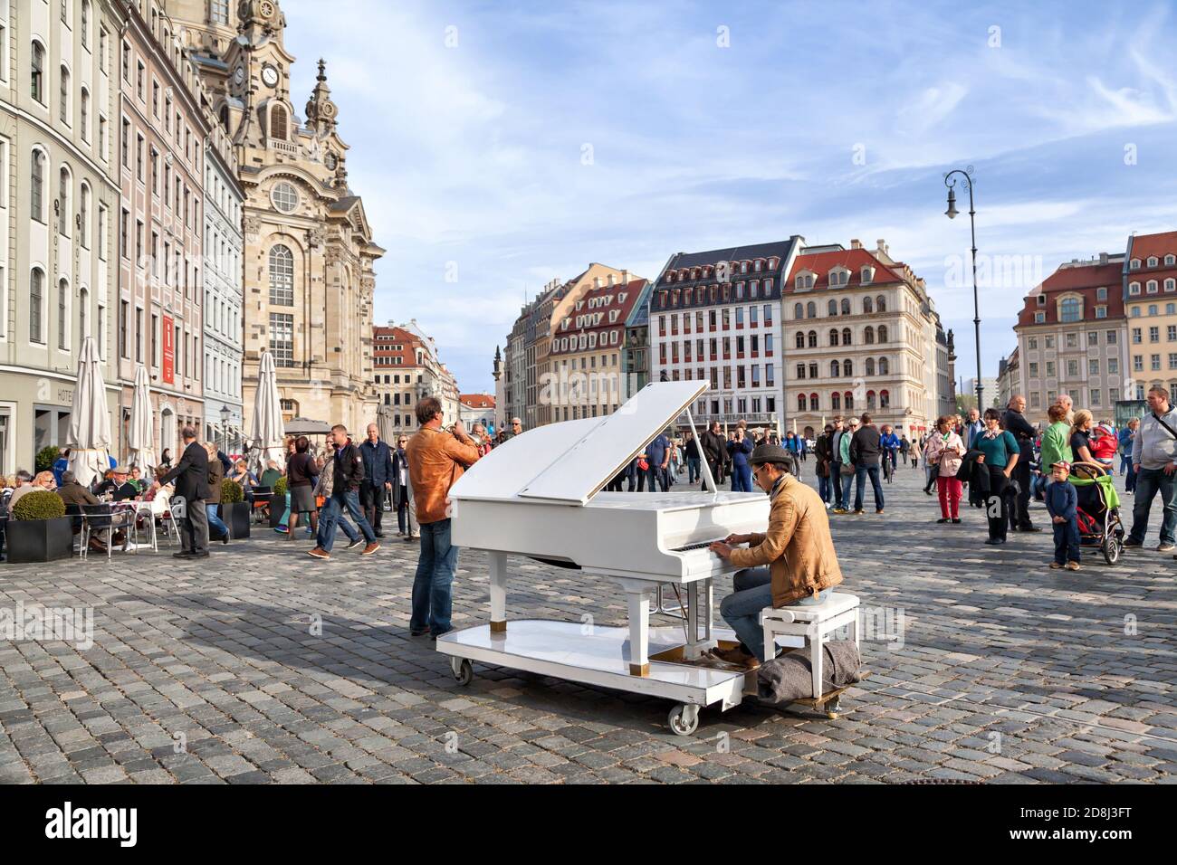 Dresden, Germany - 03 October 2015: Unidentified man plays on a white grand piano on Neumarkt square in the center of Dresden Stock Photo