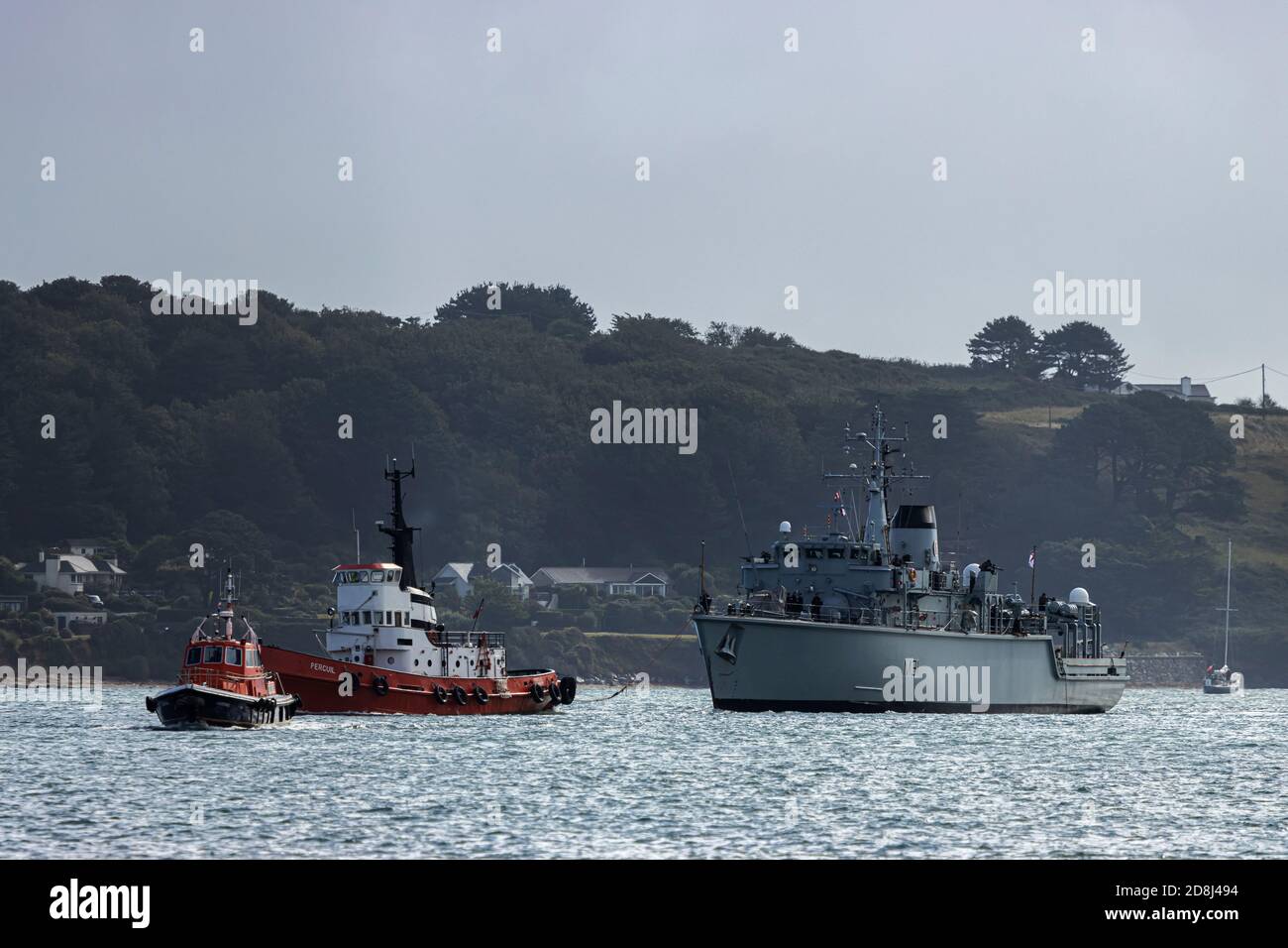 A pilot leading a tug pulling a navy boat Stock Photo