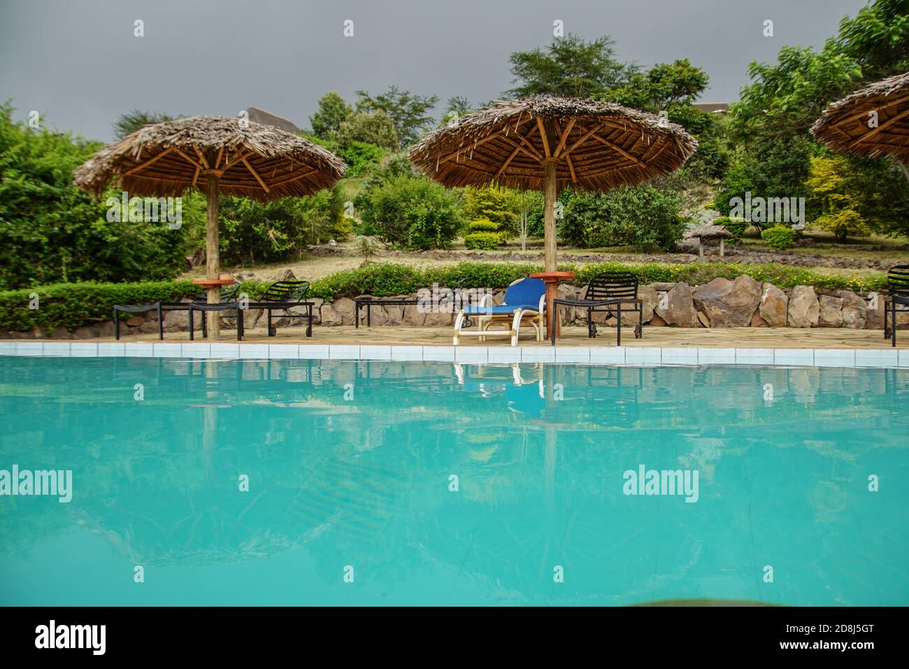 Umbrella and chair beside a pool Stock Photo - Alamy