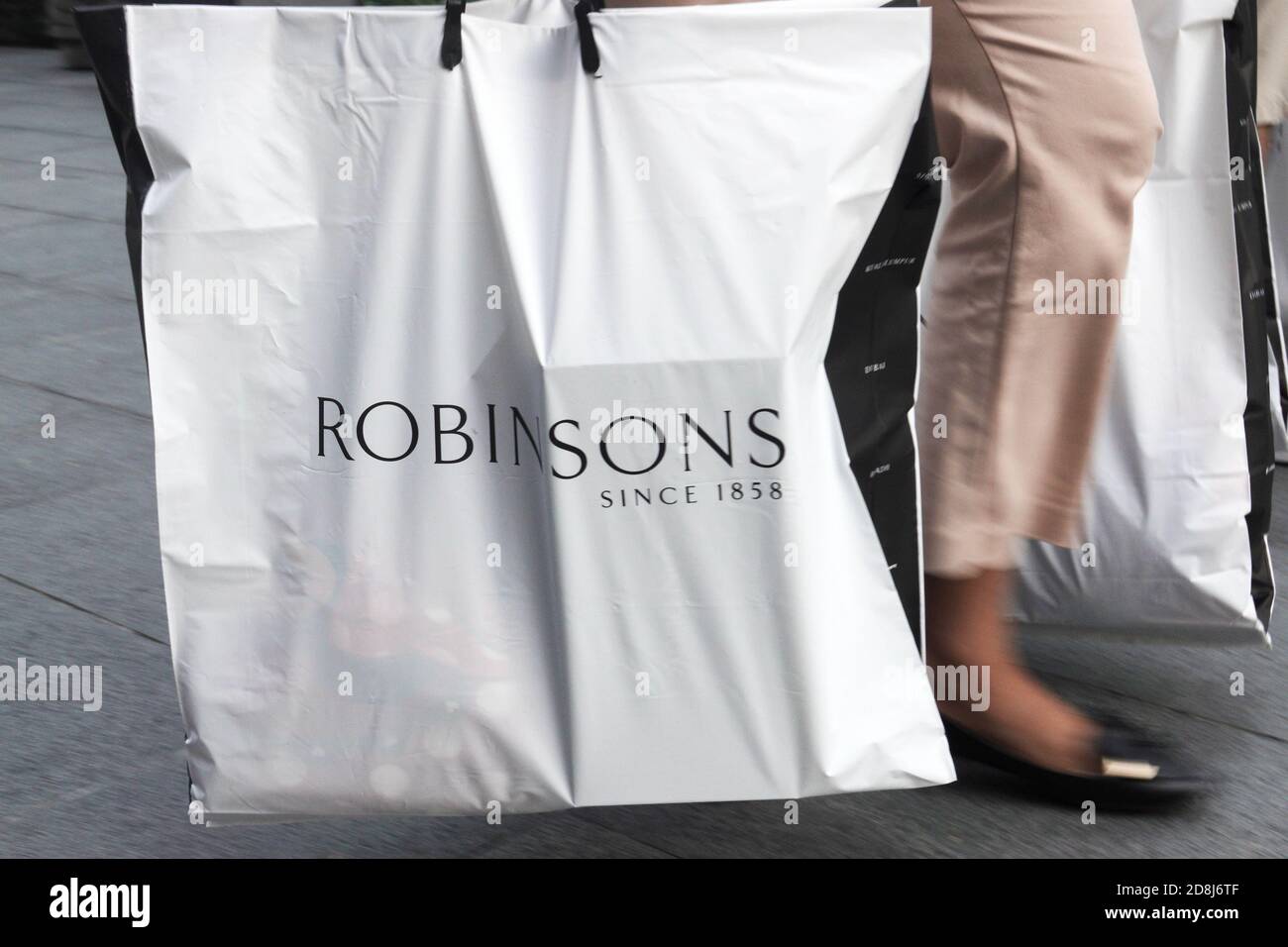 (201030) SINGAPORE, Oct. 30, 2020 (Xinhua) A shopper carries her shopping bags from the