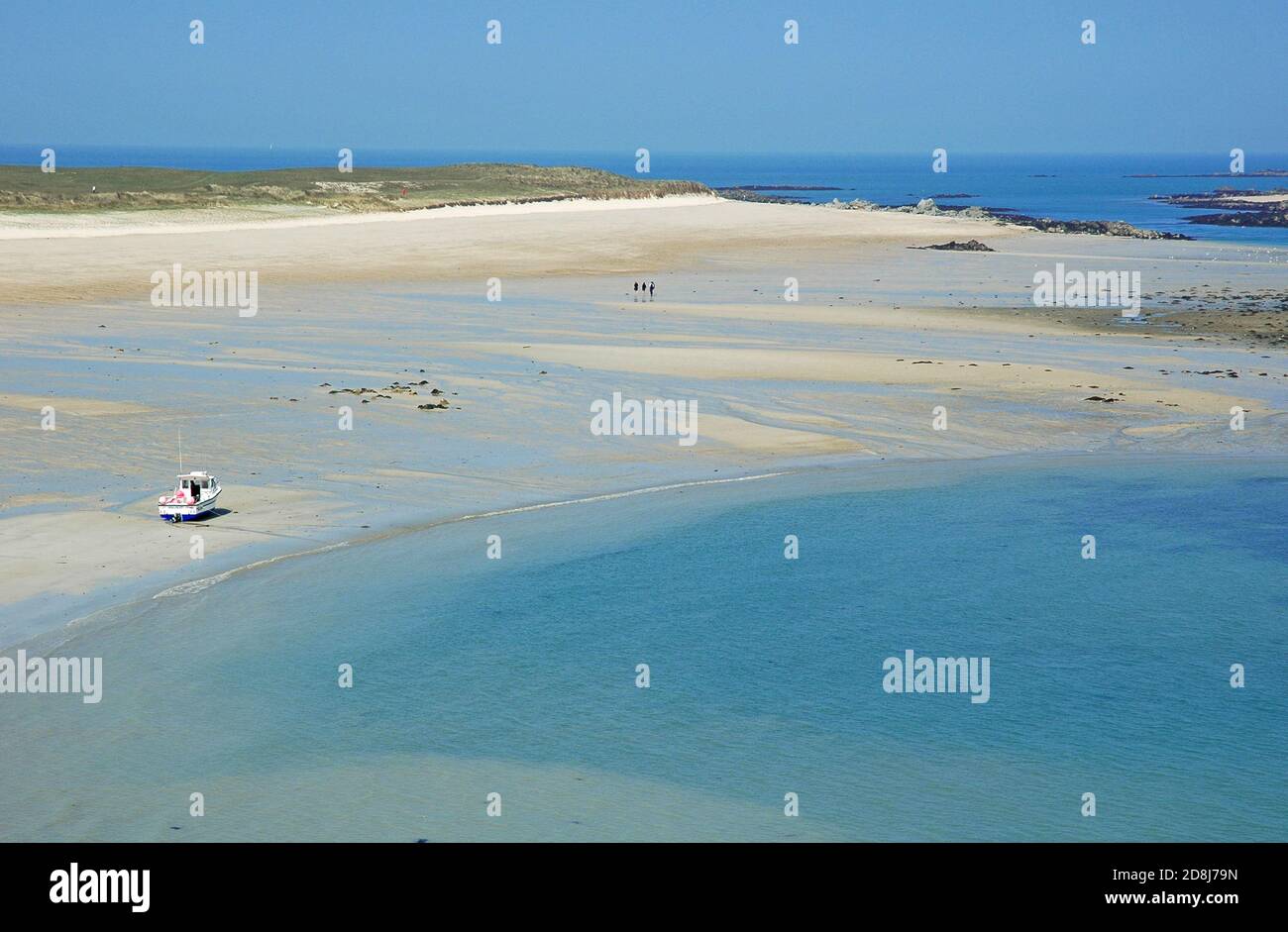 The Shell Beach, Herm, Channel Islands, April.  People walking.  Launch moored. Stock Photo