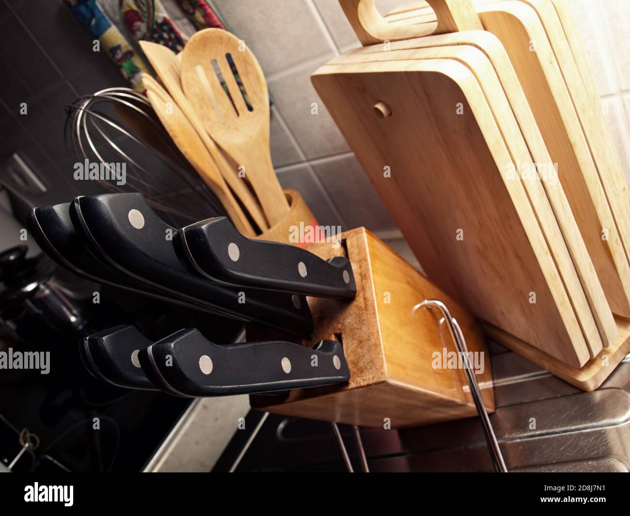 Detail from the home kitchen with a set of knives in the foreground. Stock Photo