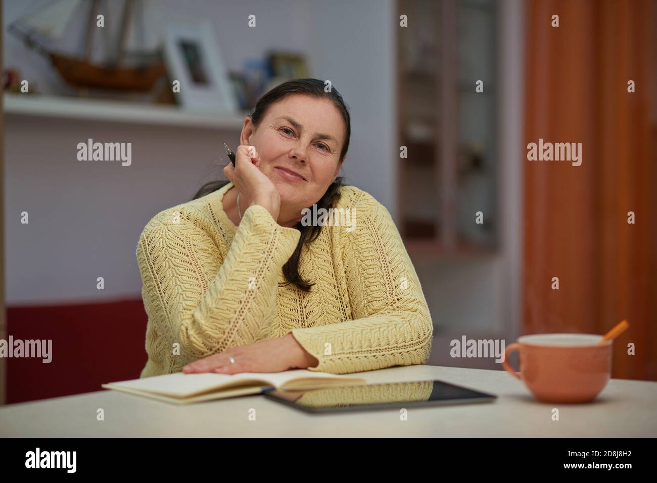Senior woman in yellow sweater looking in the camera Stock Photo