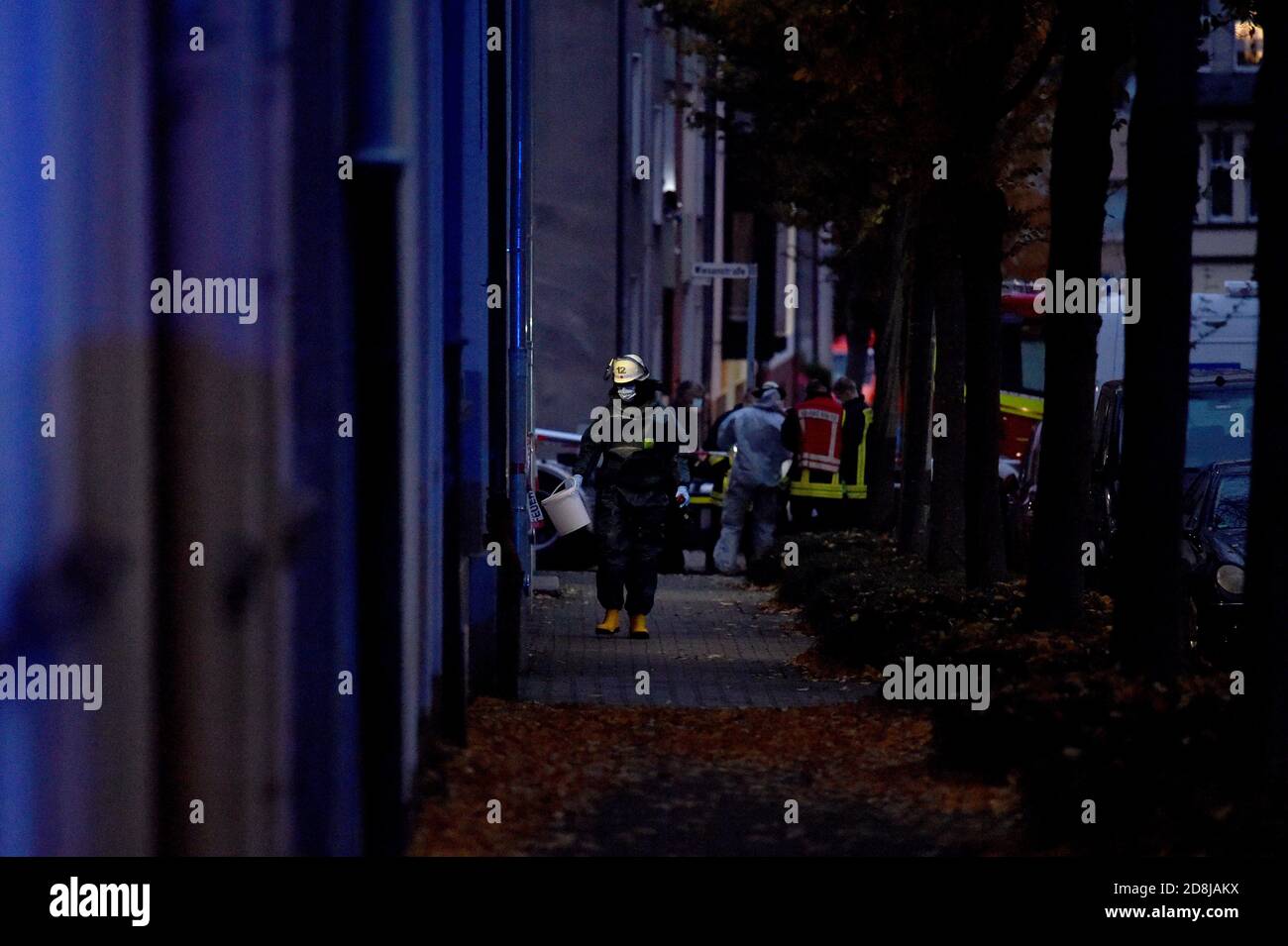 Gelsenkirchen, Germany. 30th Oct, 2020. A fireman walks with a bucket to a house where highly explosive chemicals have been discovered in an apartment. Relatives of a deceased man had found picric acid when clearing out the apartment. Three apartment buildings were cleared for safety reasons. Credit: Caroline Seidel/dpa Credit: dpa picture alliance/Alamy Live News/dpa/Alamy Live News Stock Photo