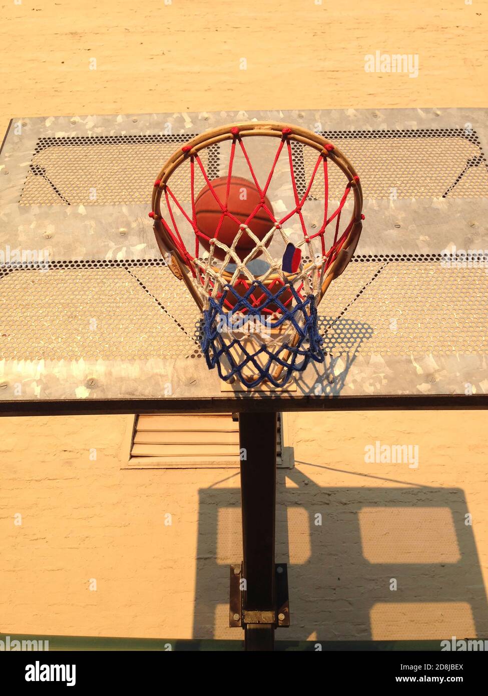 Low Angle View of Basketball Hoop and Ball Stock Photo