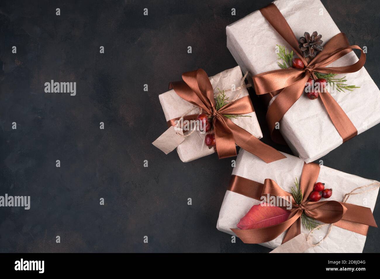 Three beautifully decorated gift boxes on a brown background. Stock Photo