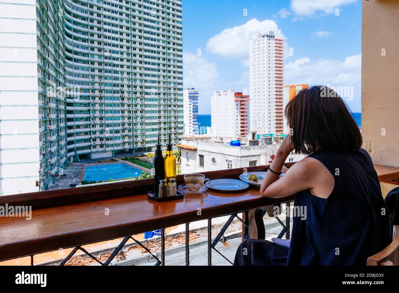 A woman looks at the skyscrapers of Vedado from the terrace of the Paladar Café Laurent. La Habana - La Havana, Cuba, Latin America and the Caribbean Stock Photo