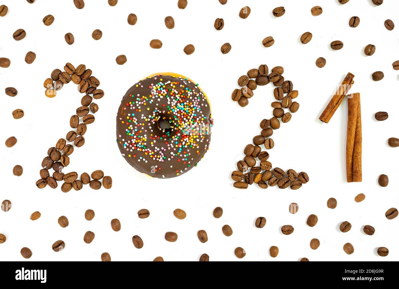 New year 2021 made of donut, coffee beans and cinnamon sticks on the white background. Stock Photo