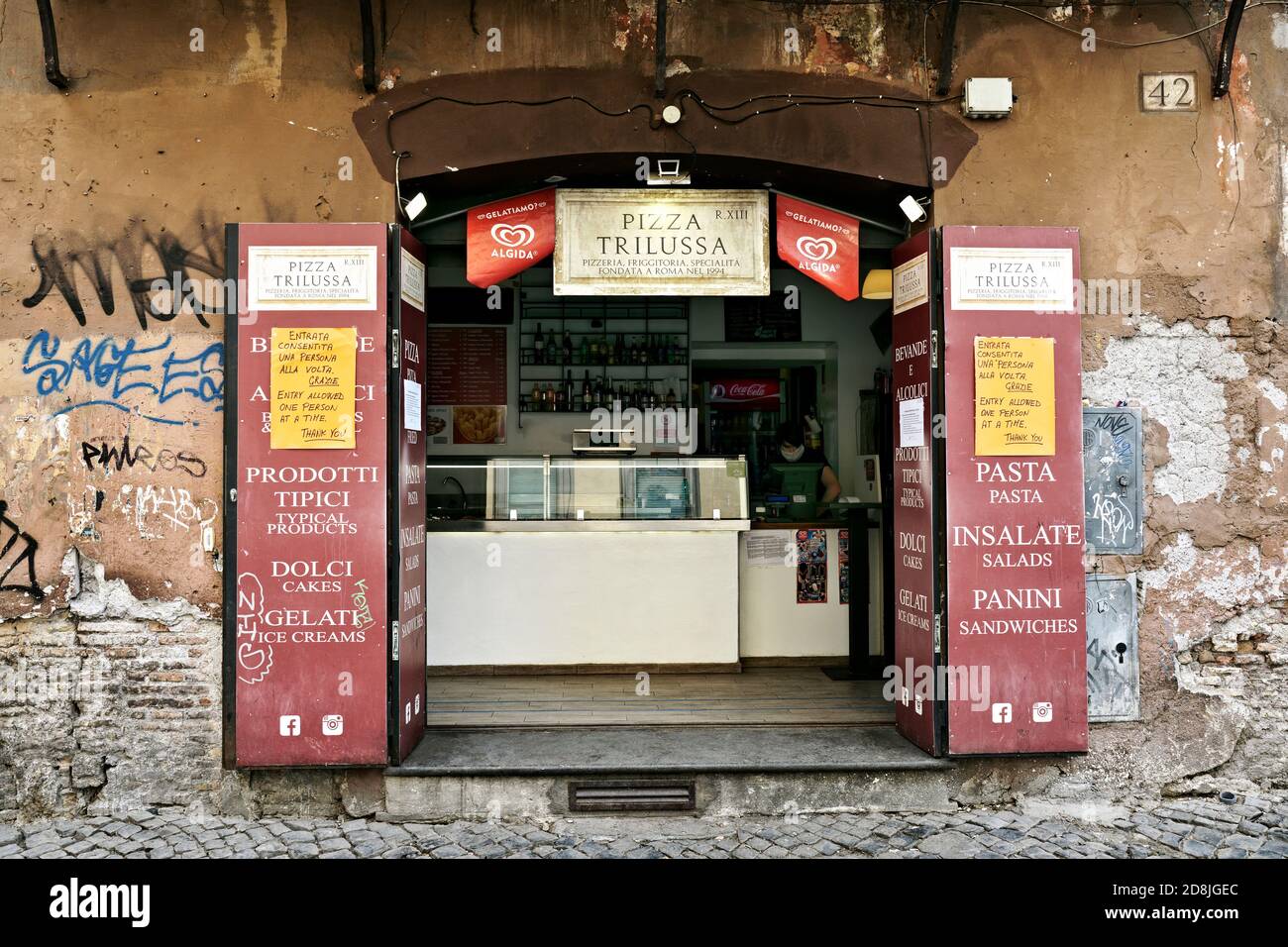 Typical pizzeria, banner signs indicating provisions for lockdown at the time of Covid 19, Corona Virus. Trastevere neighborhood. Rome, Italy, Europe. Stock Photo