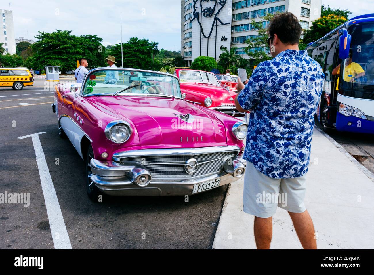 Tourist takes pictures of a vintage taxi - Almendrón - near Revolution Square - Plaza de la revolución. La Habana - La Havana, Cuba, Latin America and Stock Photo