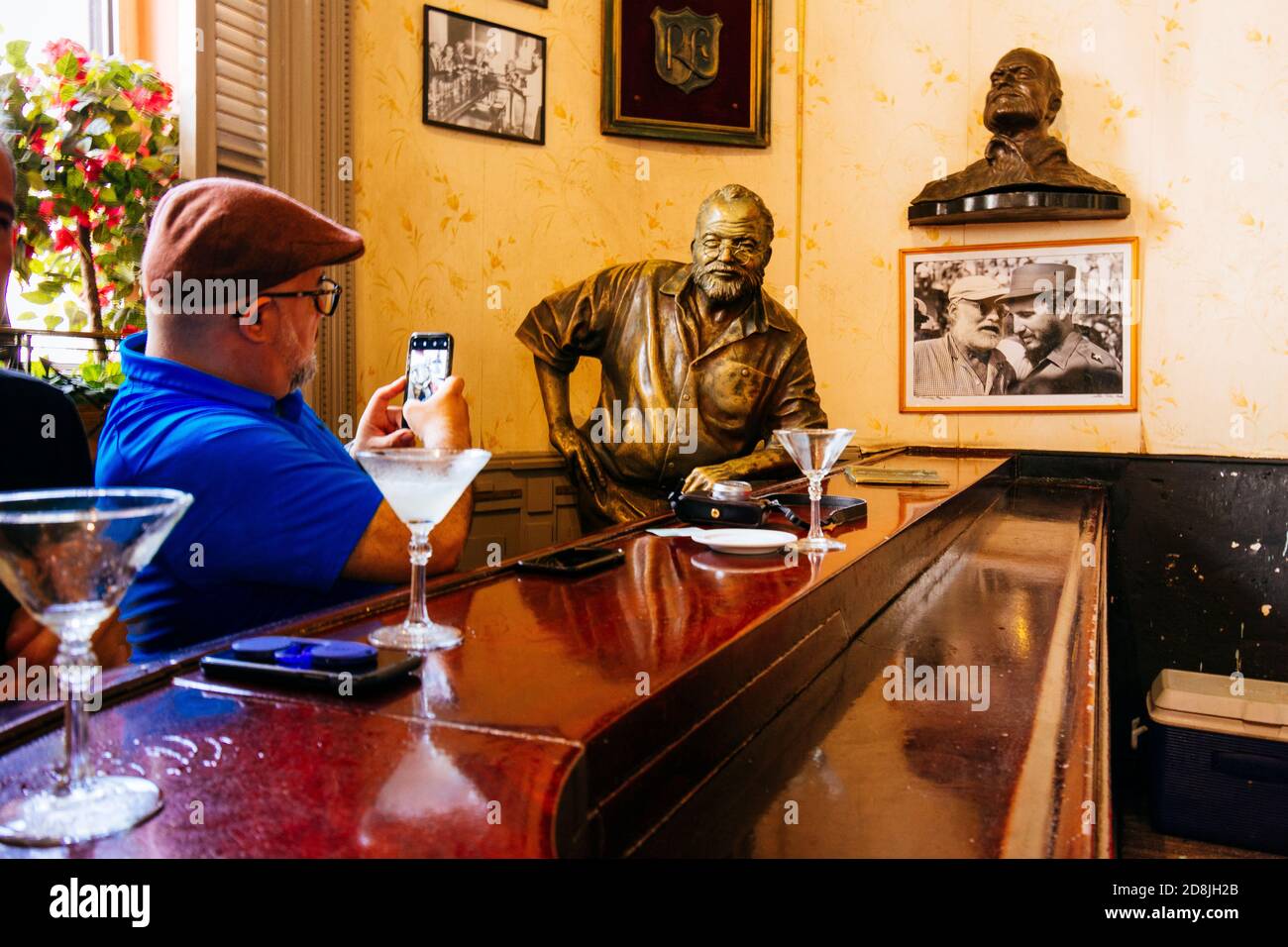 A tourist photographs the statue of Hemmingway in a corner of El Floridita's bar. La Habana - La Havana, Cuba, Latin America and the Caribbean Stock Photo