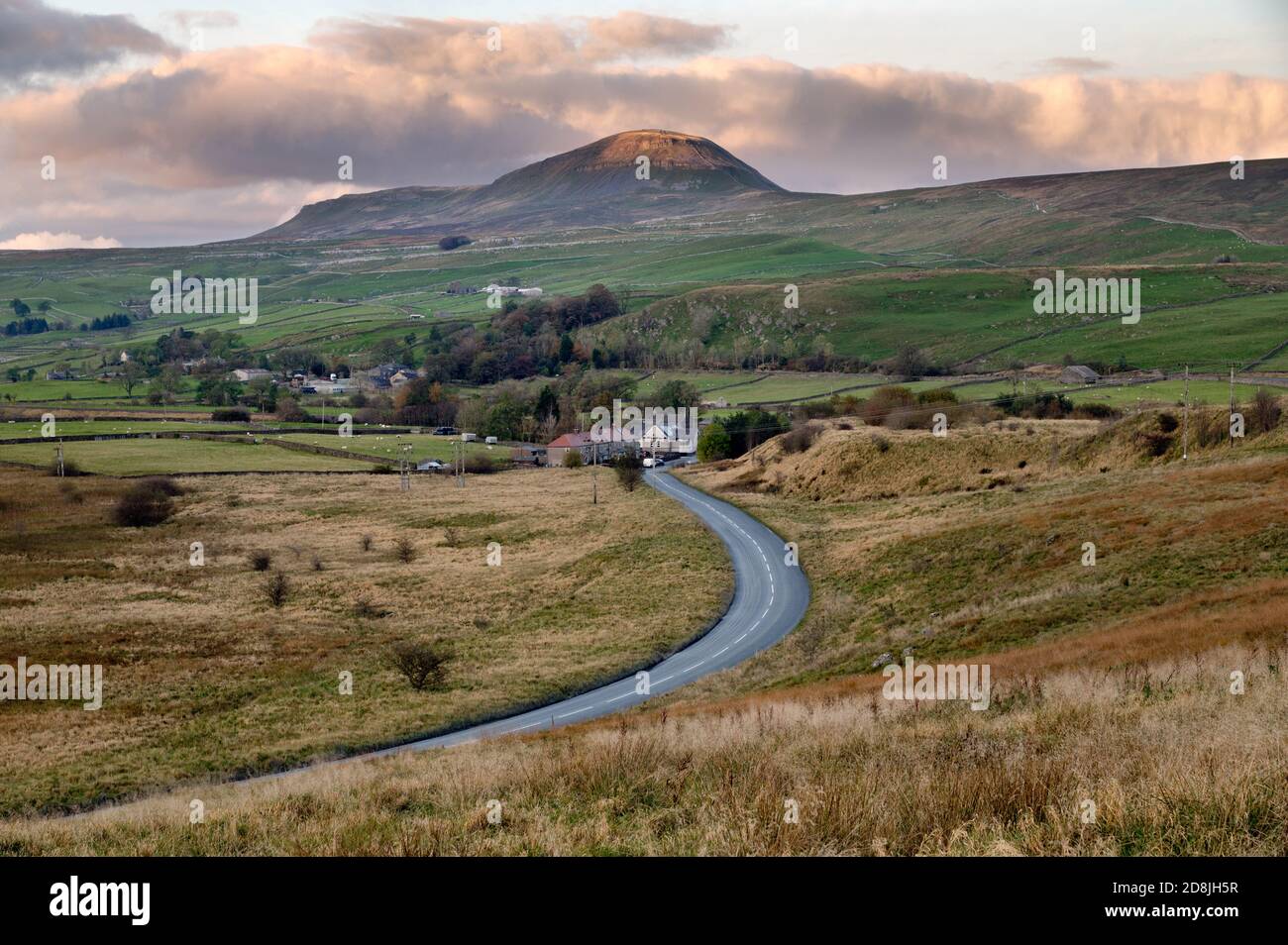 Afternoon Autumn light on Pen-y-ghent, one of the famous Three Peaks in the Yorkshire Dales National Park. Helwith Bridge is seen in the foreground. Stock Photo