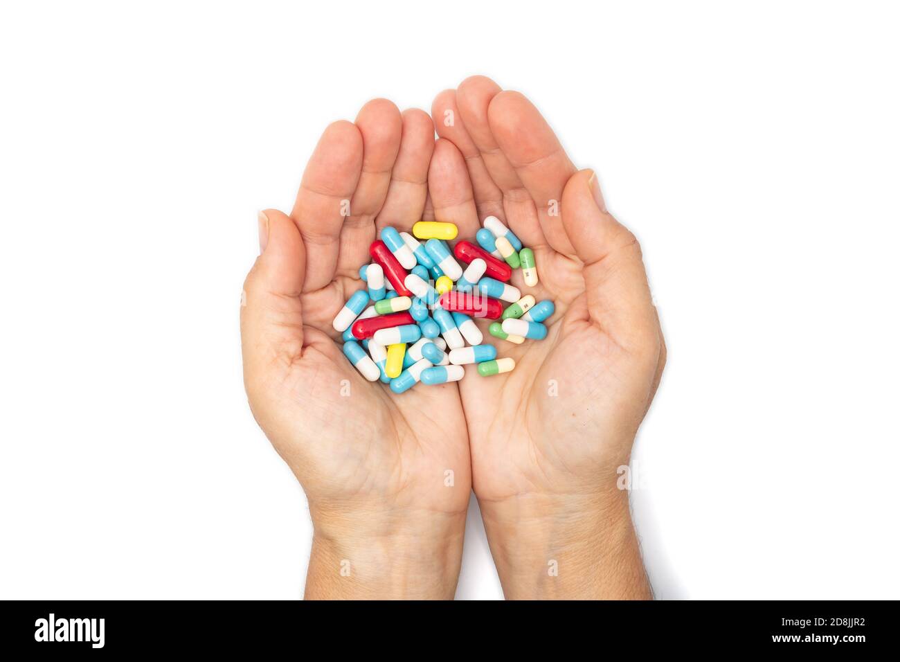 A handful of colored pills in the hands Stock Photo