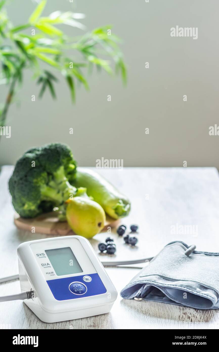 Blood pressure monitor on a table next to table of green fruits and