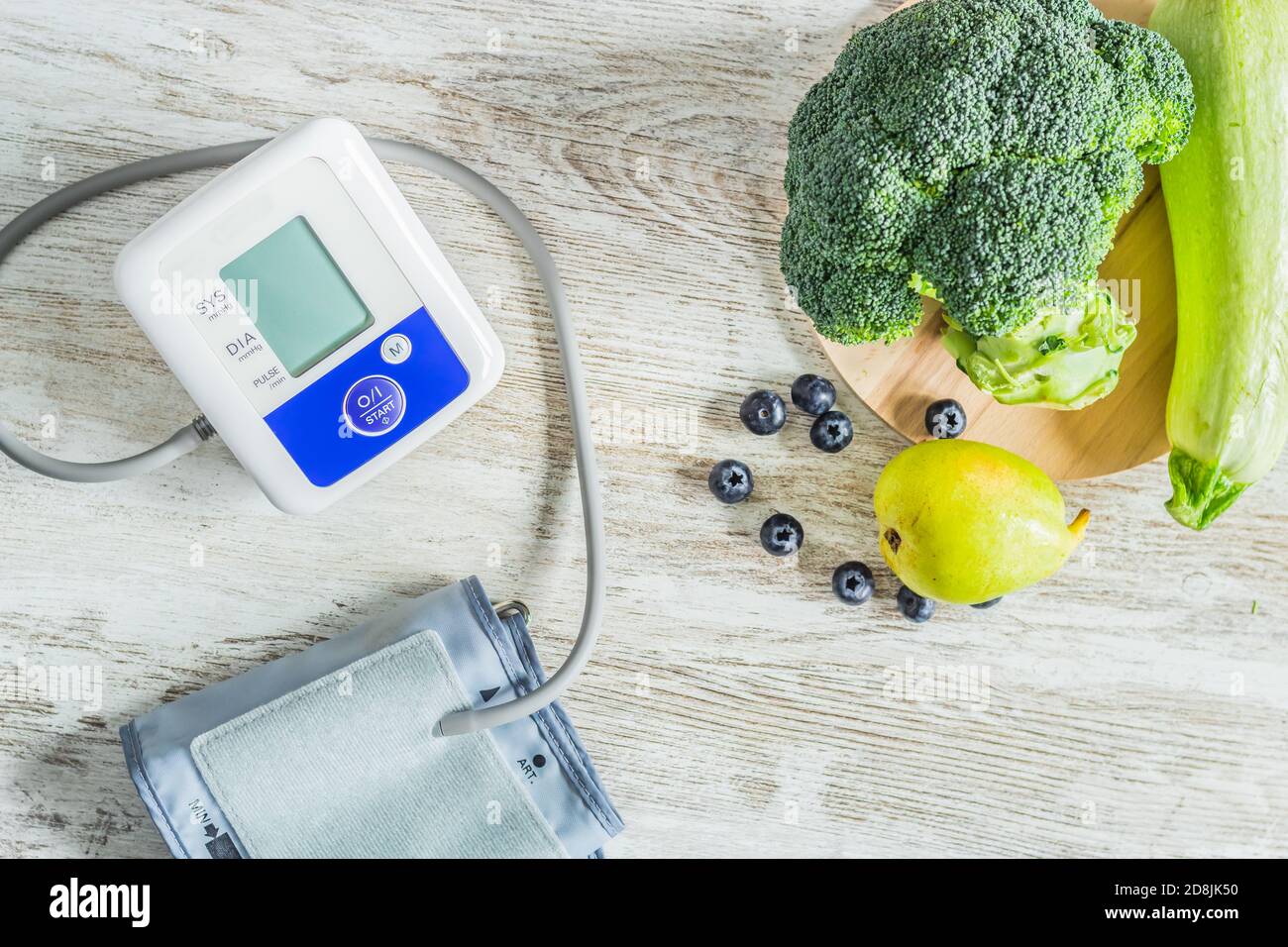 Blood pressure monitor on a table next to table of green fruits and