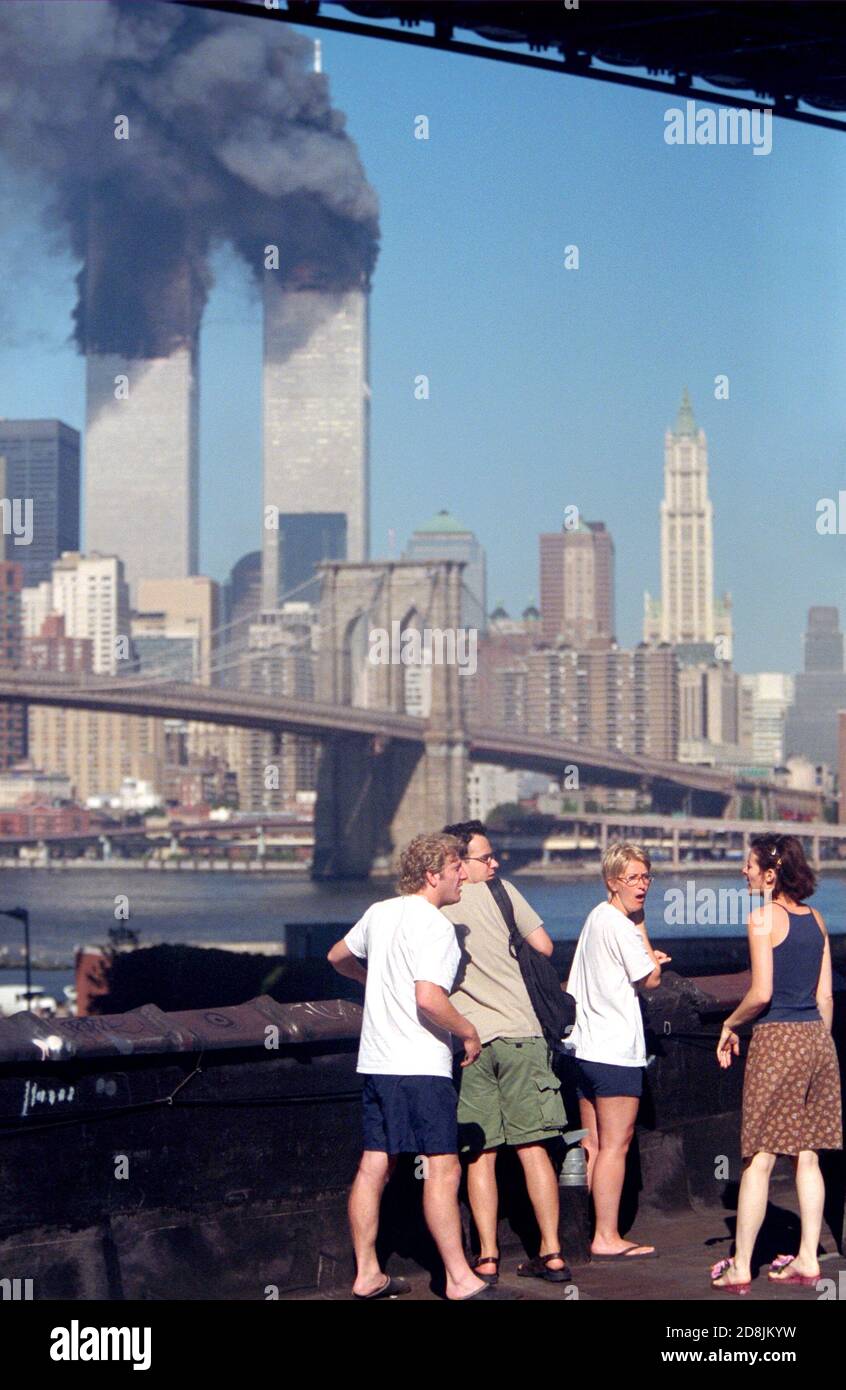 Residents on the rooftop of an apartment building in Brooklyn watching the Twin Towers burn, react to finding out that the Pentagon in Washington D.C. Stock Photo