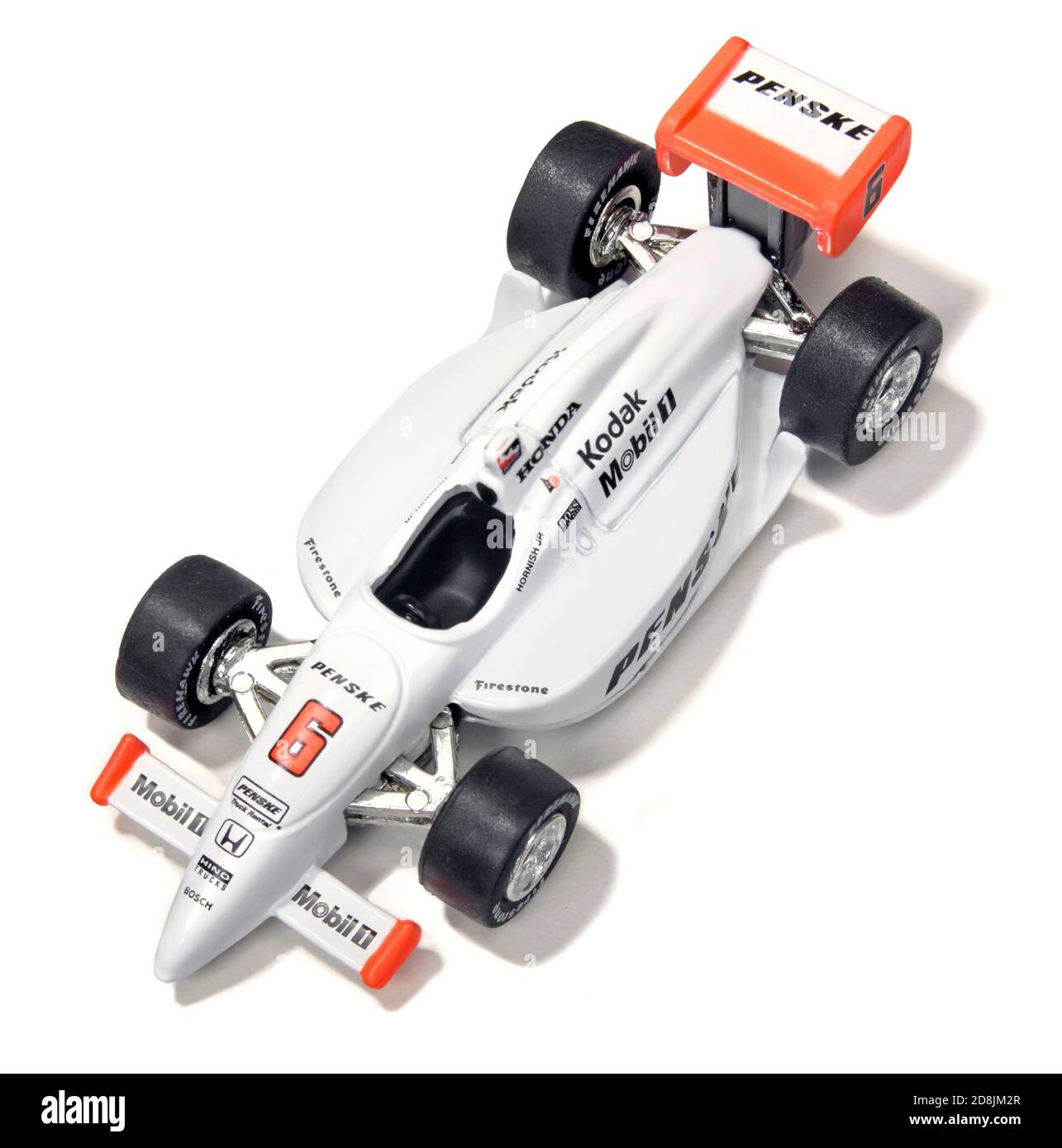 White Penske toy race car with orange accents and sponsor logos photographed on a white background Stock Photo