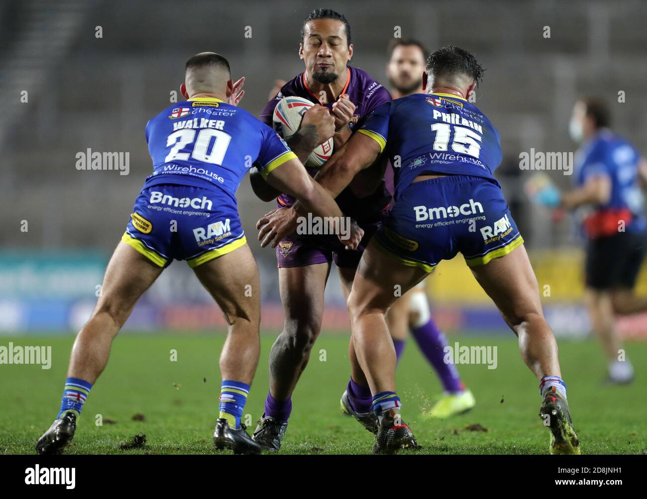 Huddersfield Giants' James Gavet (centre) is tackled by Warrington Wolves' Danny Walker (left) and Joe Philbin during the Betfred Super League match at the Totally Wicked Stadium, St Helens. Stock Photo