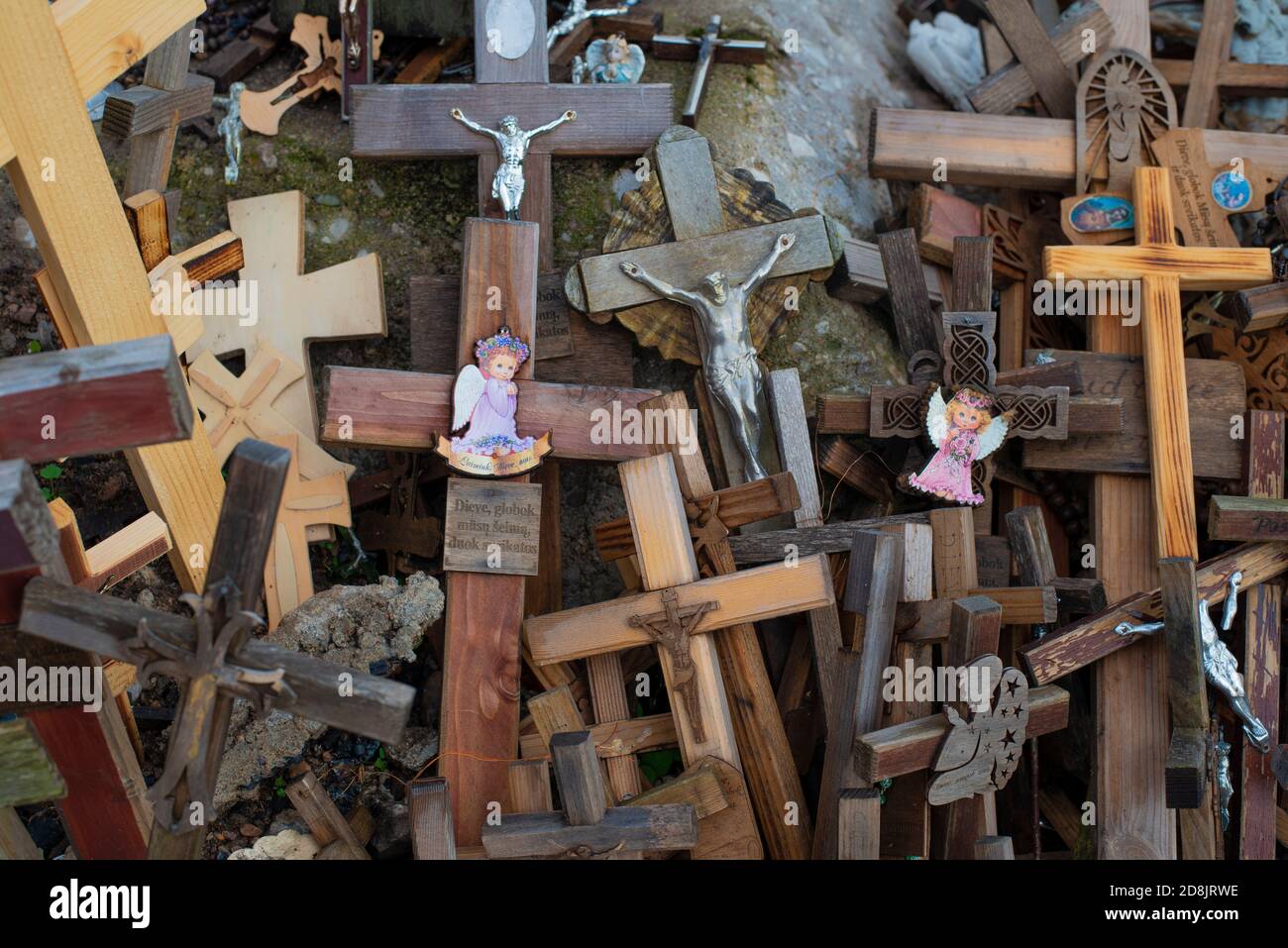 LITHUANIA, SIAULIAI, 2016-07-28: : Small shrine with figures of angels surrounded by wooden crosses on the hill of crosses (Kryzio Kainas) one of the Stock Photo